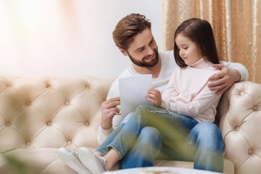 Kızıyla birlikte oturan yakışıklı sakallı adam