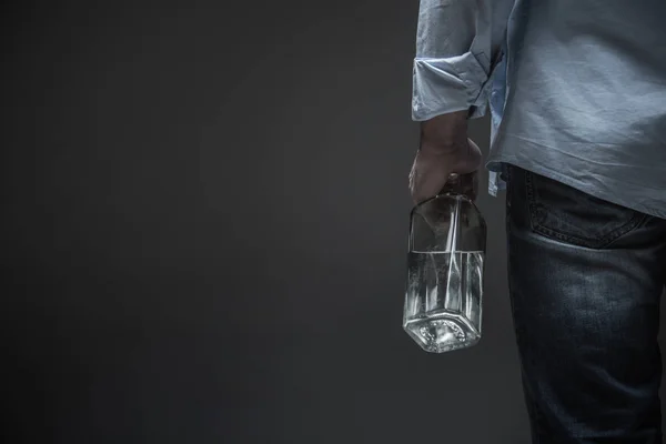 Photo of male back holding bottle in hand — Stock Photo, Image