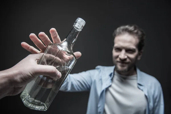 Delighted man taking big glass bottle — Stock Photo, Image