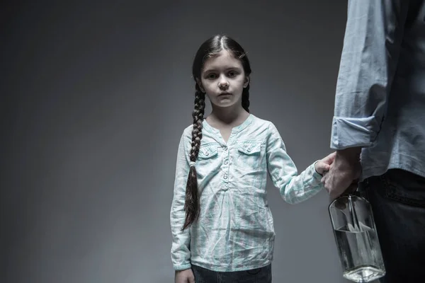 Smutně vypadající dívka se dotýká ruka jejího otce — Stock fotografie