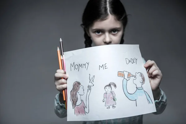 Menina segurando retrato de sua família em ambas as mãos — Fotografia de Stock