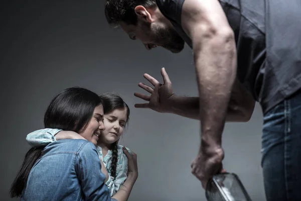 Homem irritado com garrafa na mão gritando com esposa e filha — Fotografia de Stock