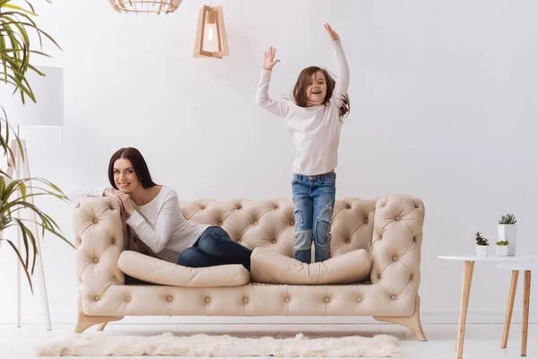 Positivo feliz menina pulando no o sofá — Fotografia de Stock