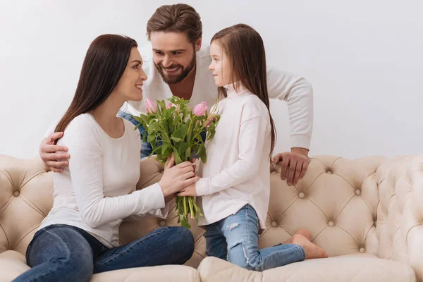 Menina encantada bonito dando um buquê de flores para sua mãe — Fotografia de Stock