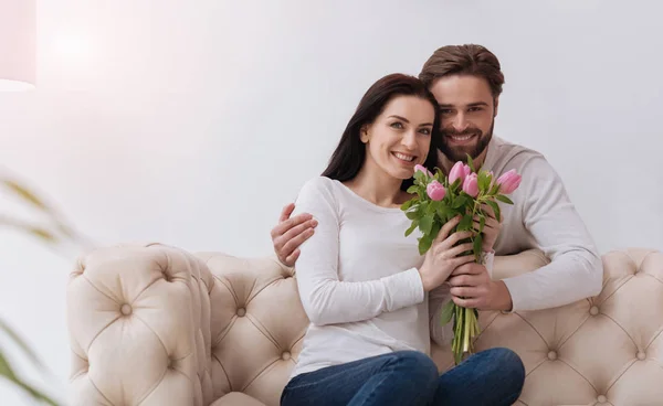 Bonita pareja agradable sosteniendo flores — Foto de Stock