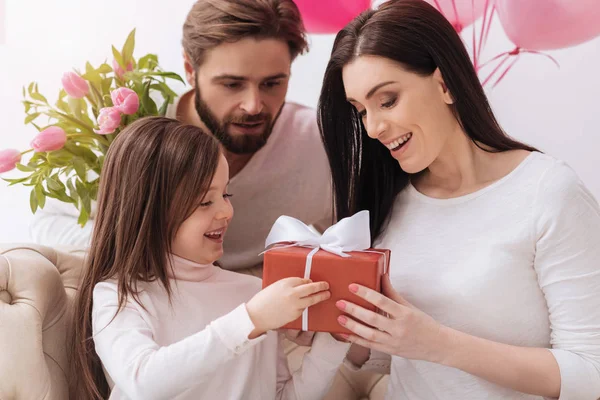 Linda madre e hija positiva sosteniendo una caja de regalo —  Fotos de Stock