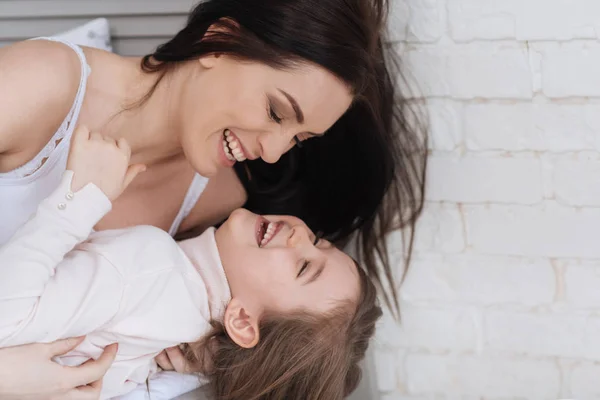 Cheerful laughing mother holding her daughter — Stock Photo, Image