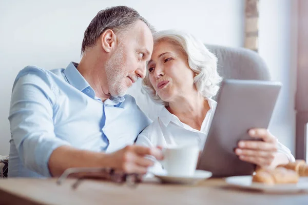 PLeasant casal amoroso envelhecido sentado à mesa — Fotografia de Stock