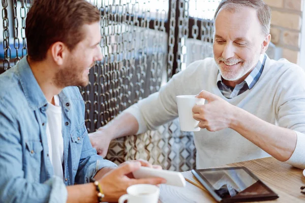 Freudig entzückter Mann und sein Großvater ruhen sich im Café aus — Stockfoto