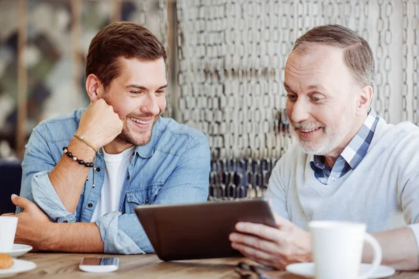 Uomo positivo e suo nonno riposano insieme nel caffè — Foto Stock