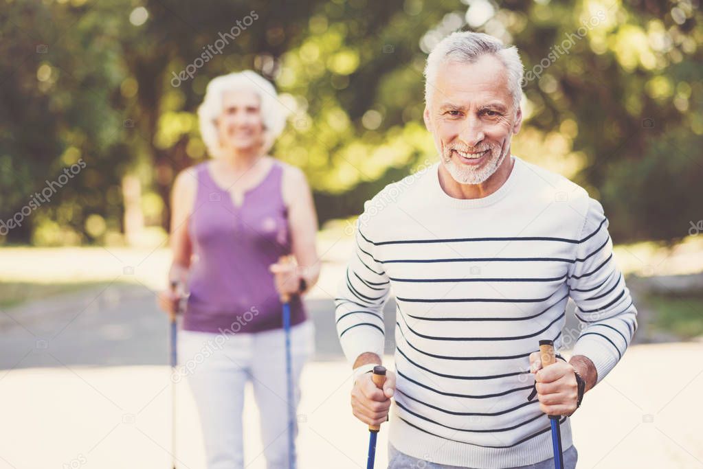 man holding walking poles and smiling