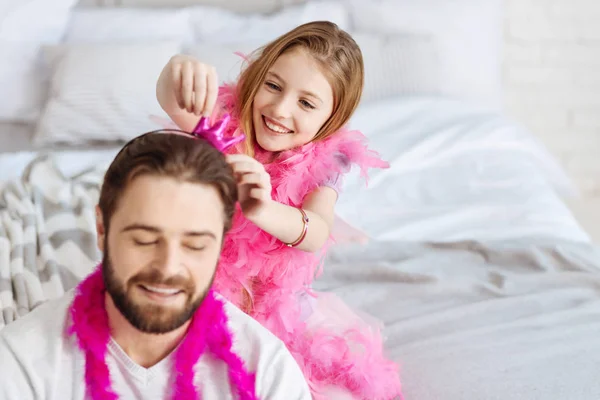 girl trying to put hoop on father