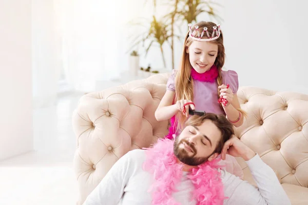 Attractive girl brushing hair of father