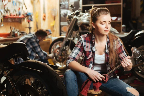 Mycket uppmärksam kvinna som arbetar i garaget av hennes pojkvän — Stockfoto