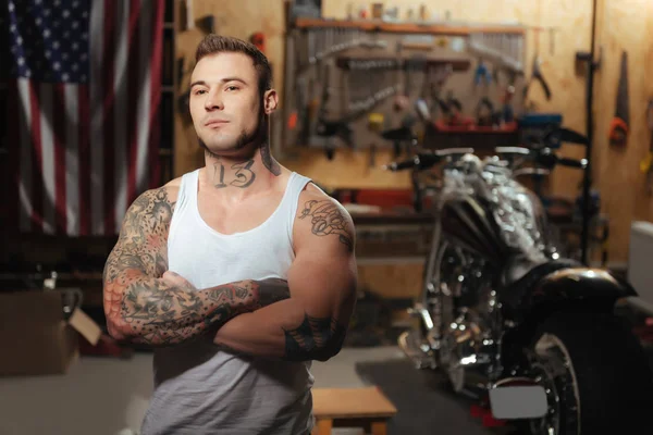 Portrait of muscular male standing in the garage — Stock Photo, Image