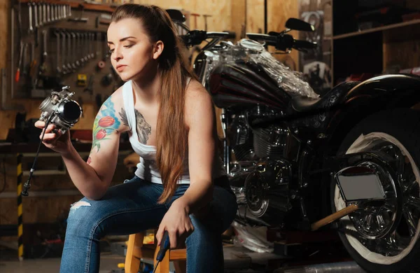 Motociclista sério feminino mantendo chave de fenda na mão esquerda — Fotografia de Stock