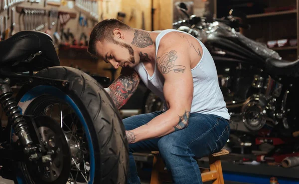 严肃的人修理他的摩托车 — 图库照片