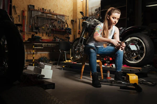 Woman sitting  in the garage — Stock Photo, Image