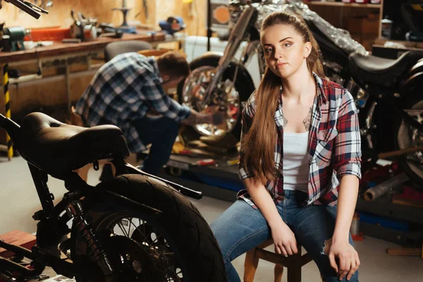 Ernstige vrouw zitten in de garage — Stockfoto