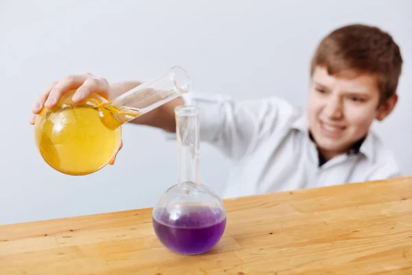 Boy pouring chemical reagent — Stock Photo, Image