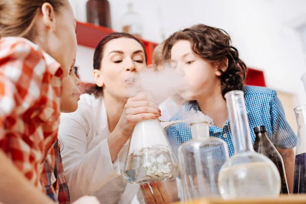 Children blowing on chemical flask — Stock Photo, Image