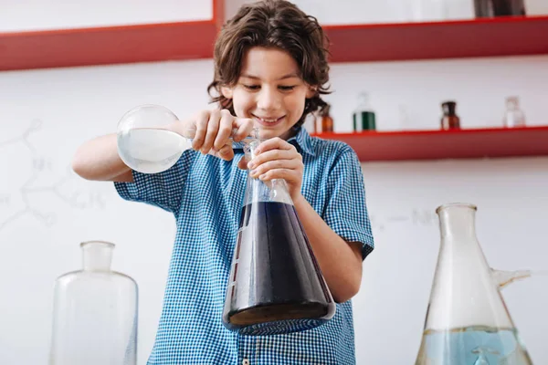 Boy mixing chemical liquids — Stock Photo, Image