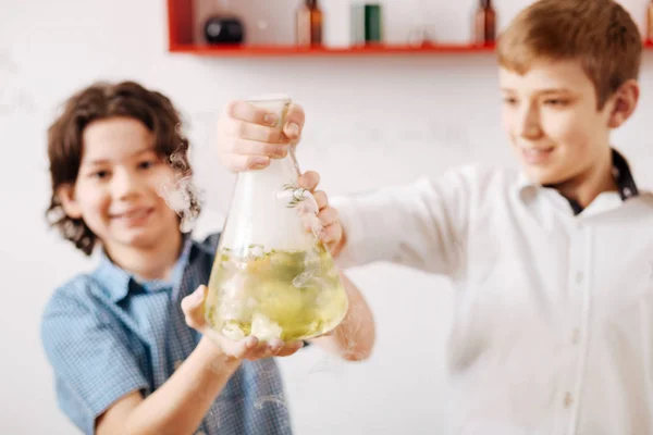 Boys smiling and holding a chemical flask — Stock Photo, Image
