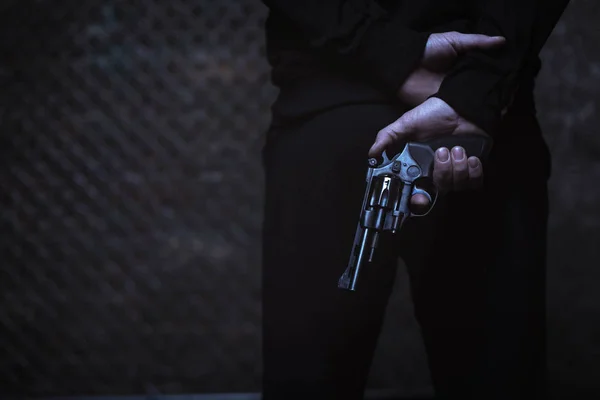 Muž krycí zbraň za zády — Stock fotografie