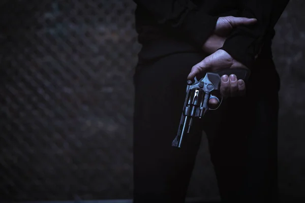 Man covering weapon behind back — Stock Photo, Image