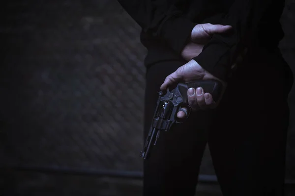 Muž krycí zbraň za zády — Stock fotografie