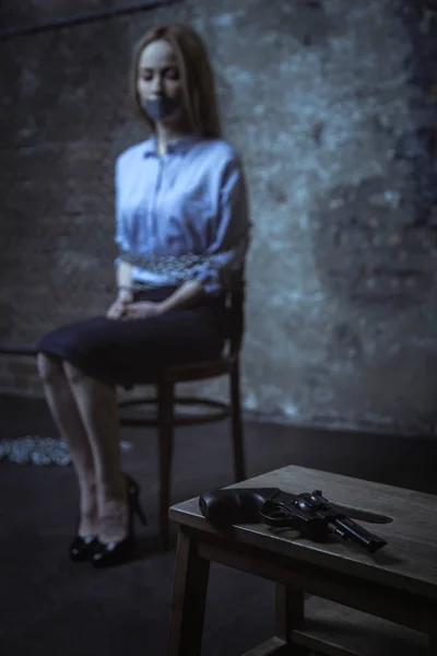 Young woman looking at gun — Stock Photo, Image