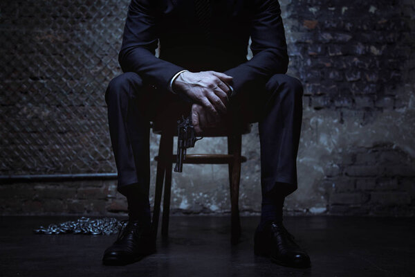 Бизнесмен держит пистолет в руках
 