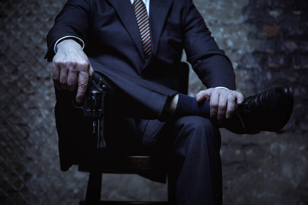 Бизнесмен держит пистолет в руках
 
