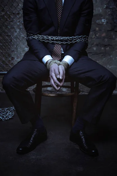 Gentleman sitting while being chained — Stock Photo, Image