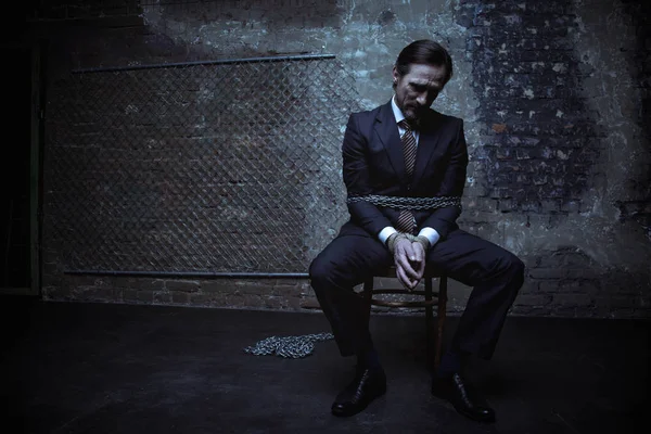 Cavalheiro sentado enquanto está acorrentado — Fotografia de Stock