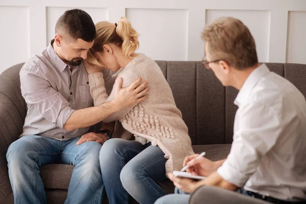 Hombre sentado cerca de esposa y abrazos —  Fotos de Stock