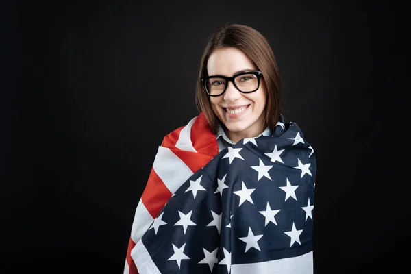 Гарненька молода жінка прикриває себе прапором — стокове фото