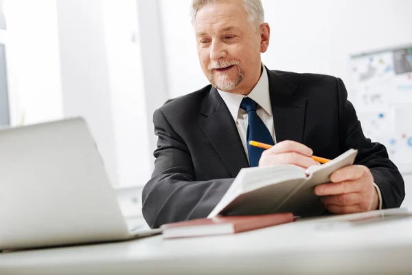 Empregador alegre tomar notas no local de trabalho — Fotografia de Stock