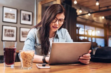 Genç kadın onun tablet ile oynayan konsantre