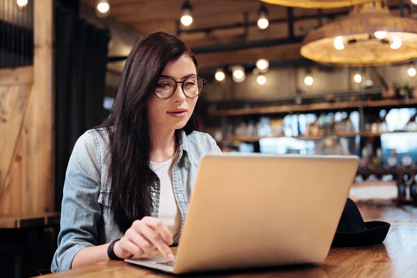 Bella bruna guardando lo schermo del suo computer portatile — Foto Stock