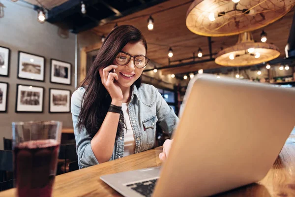 Positive delighted young woman looking at laptop — Stock Photo, Image