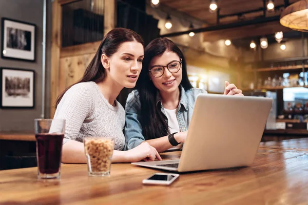 Duas meninas amigáveis olhando para a tela do computador — Fotografia de Stock