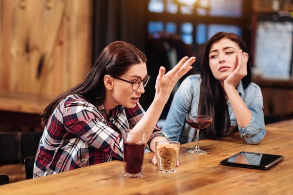 Увлеченный дискуссионной девушкой, держащей стакан с арахисом — стоковое фото