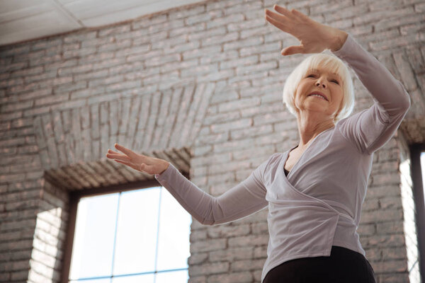 Elderly woman dancing in ballroom 