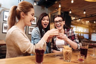 Bardakları tokuşturup gülümseyen genç kadın
