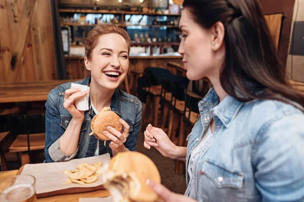 Θετικά μεγάλη χαρά γυναίκα κρατώντας burger στο αριστερό χέρι — Φωτογραφία Αρχείου