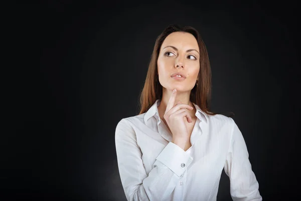 Attractive woman holding her forefinger on chin — Stock Photo, Image