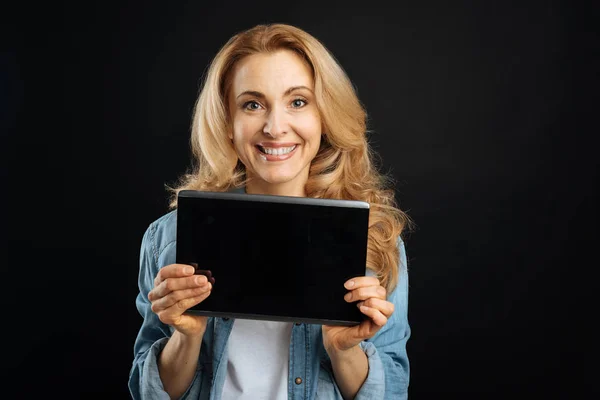 Pěkně usmívající se žena reklamní černý tablet — Stock fotografie