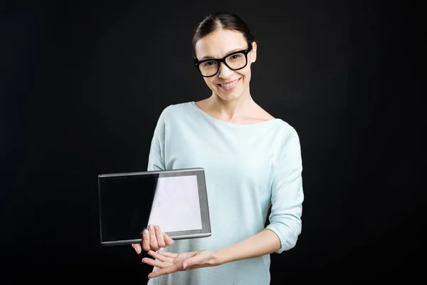 Positiv erfreute Studentin zeigt ihr Gerät — Stockfoto