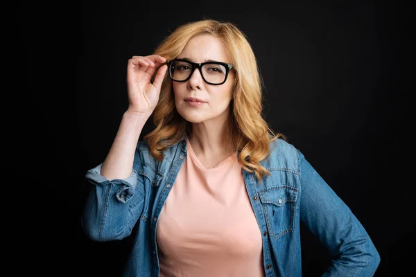 Seriös kvinna medan röra glasögon — Stockfoto